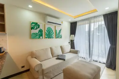 a living room with a couch and a window at Calipso Garden 312 in Rawai Beach