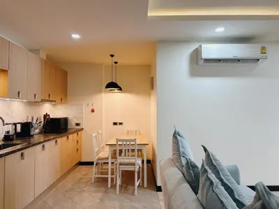 a kitchen and a living room with a couch and a table at Calipso Garden 312 in Rawai Beach