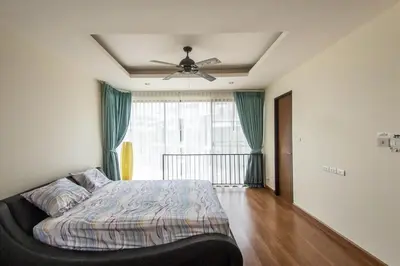 a bedroom with a bed and a ceiling fan at Spacious 3 bedroom townhouse in Laguna in Laguna Phuket