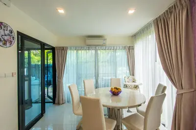 a dining room with a table and chairs at Spacious 3 bedroom townhouse in Laguna in Laguna Phuket