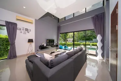 a living room with a couch and a large window at \u4e5d\u96c5\u96c6 The Nine Refined Retreats in Rawai Beach