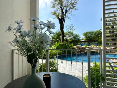 a vase with flowers sitting on a table next to a pool at JU3 Halo NEW ВатСaп66935B2I976 in Nai Yang Beach