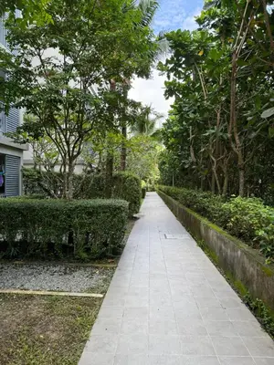 a walkway in a garden with bushes and trees at The title Naiyang - Beach Condos in Nai Yang Beach