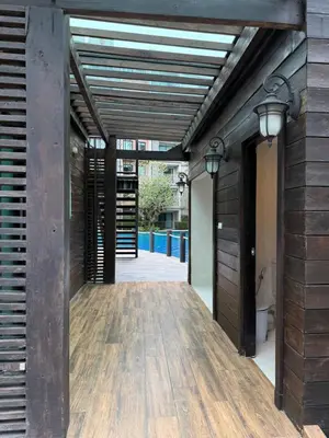 an open hallway with a wooden floor and two lights at The title Naiyang - Beach Condos in Nai Yang Beach