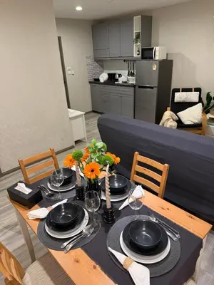 a dining room table with black plates and flowers on it at The title Naiyang - Beach Condos in Nai Yang Beach