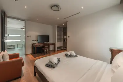 a bedroom with a bed and a desk and a television at V203 Seahorse Villa Stunning 4BR Oceanview Retreat in Bang Tao Beach