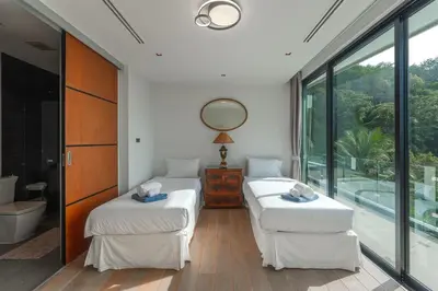 two beds in a room with large windows at V203 Seahorse Villa Stunning 4BR Oceanview Retreat in Bang Tao Beach