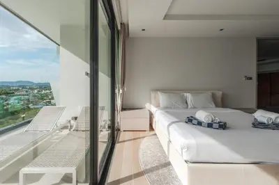 a bedroom with a white bed and a balcony at V203 Seahorse Villa Stunning 4BR Oceanview Retreat in Bang Tao Beach