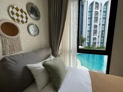 a bedroom with a bed and a window with a pool at TheTitleHalo1 in Phuket