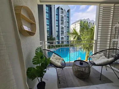 a balcony with chairs and a view of a pool at TheTitleHalo1 in Phuket