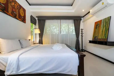 a bedroom with a white bed and a window at Villa Prima - 3 Bedroom Private Pool Villa in Rawai Beach