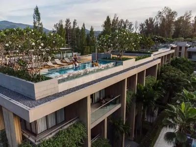 an apartment building with a swimming pool and trees at JSD Prime Property-Kamala Beach in Surin Beach