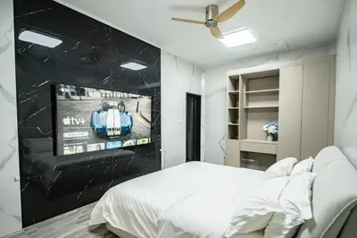 a bedroom with a bed and a tv on a wall at DreamHouse in Ban Bang Khu