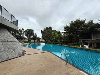 a large blue swimming pool next to a building at DreamHouse in Ban Bang Khu