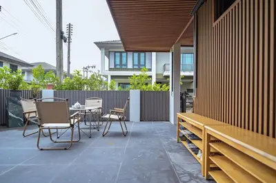 a patio with chairs and a table and a fence at DreamHouse in Ban Bang Khu