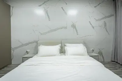 a bedroom with a white bed with two pillows at DreamHouse in Ban Bang Khu