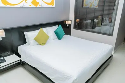 a bedroom with a white bed with a black headboard at Beachfront and Deluxe Pool Access Patong Phuket in Patong Beach