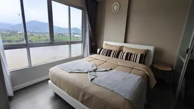 a bedroom with a bed with a large window at dcondo Mine Phuket in Kathu
