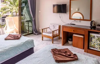 a hotel room with two beds and a mirror at Sunflower Guesthouse in Karon Beach