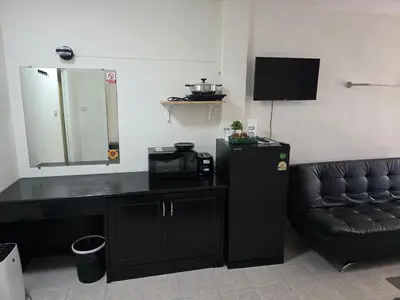 a room with a black desk and a chair and a mirror at Sunflower Guesthouse in Karon Beach
