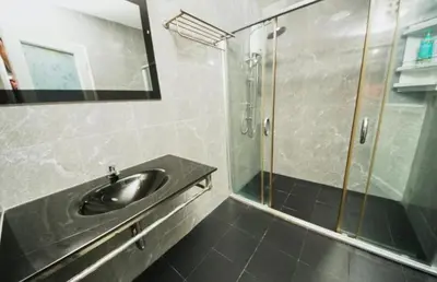 a bathroom with a sink and a glass shower at Sunflower Guesthouse in Karon Beach
