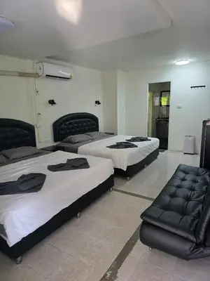 a room with two beds and a couch in it at Sunflower Guesthouse in Karon Beach