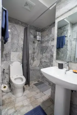 a bathroom with a white toilet and a sink at White Room in Ban Mai Salae