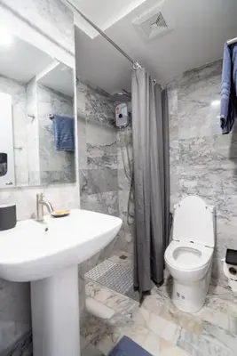 a bathroom with a white sink and a toilet at White Room in Ban Mai Salae