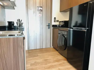 a kitchen with a dishwasher and a washer and dryer at Praud Karon in Karon Beach