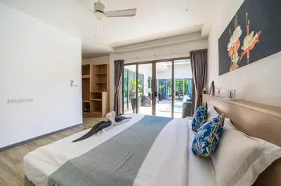 a bedroom with a large bed with blue and white pillows at Bang tao modern holiday style pool view high speed WiFi in Laguna Phuket