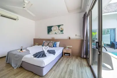 a bedroom with a bed and a sliding glass door at Bang tao modern holiday style pool view high speed WiFi in Laguna Phuket