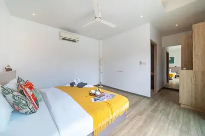 a bedroom with a large bed with a yellow blanket at Bang tao modern holiday style pool view high speed WiFi in Laguna Phuket