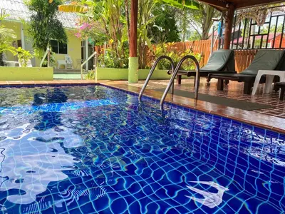 a large swimming pool with blue tiles on it at The Golden Beach Resort Naiyang in Nai Yang Beach