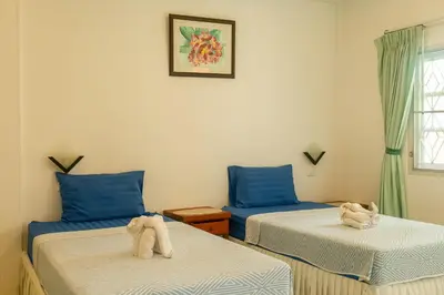 two beds with towel animals on them in a room at The Golden Beach Resort Naiyang in Nai Yang Beach