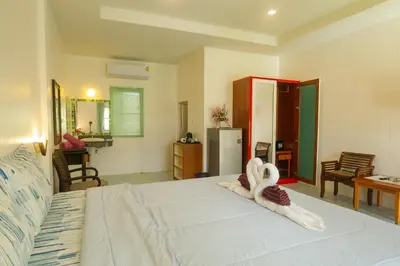a bedroom with a bed with a towel animal on it at The Golden Beach Resort Naiyang in Nai Yang Beach