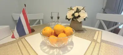 a bowl of oranges on a table with a vase of flowers at MO1 Halo 2-bedroom ВатСaп66935B2I976 in Nai Yang Beach