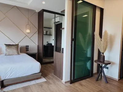 a bedroom with a bed and a glass door at Praud Karon 605 in Karon Beach
