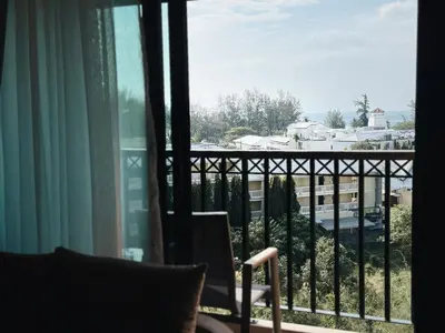a room with a view of a city from a balcony at Praud Karon 605 in Karon Beach
