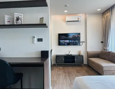 a room with a bed and a couch and a tv at Praud Karon 605 in Karon Beach