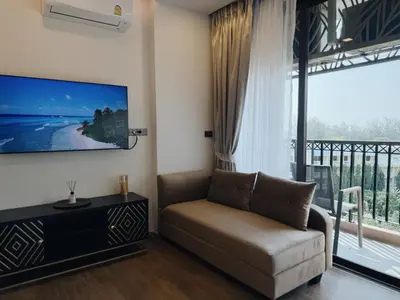 a living room with a couch and a large window at Praud Karon 605 in Karon Beach