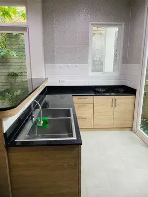 a kitchen with a stainless steel sink and a window at PhuketMadameBuppa Siwali Village in Ban Phlu Yai