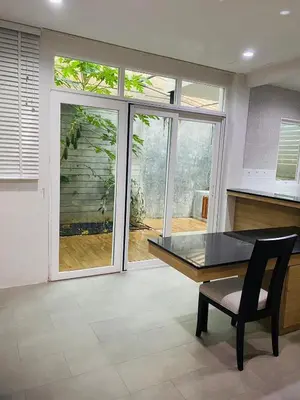 a dining room with a table and a window at PhuketMadameBuppa Siwali Village in Ban Phlu Yai