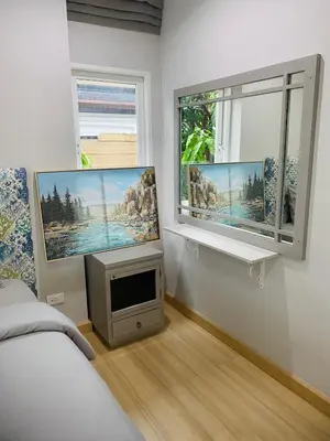 a bedroom with two large windows and a tv at PhuketMadameBuppa Siwali Village in Ban Phlu Yai