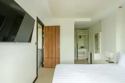 a bedroom with a white bed and a bathroom at Room 303 Rawai Beach Condo in Nai Harn Beach