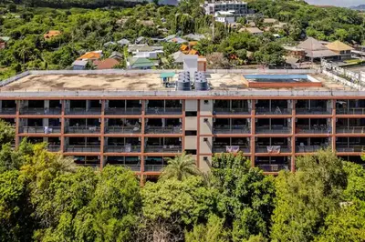 a large building with trees in front of it at Room 303 Rawai Beach Condo in Nai Harn Beach