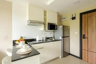 a kitchen with white cabinets and a counter top at Room 303 Rawai Beach Condo in Nai Harn Beach