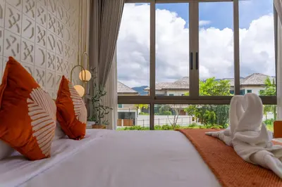 a bedroom with a bed with a large window at \u4e91\u6816\u522b\u9662 Cloudrest Villa in Phuket Town