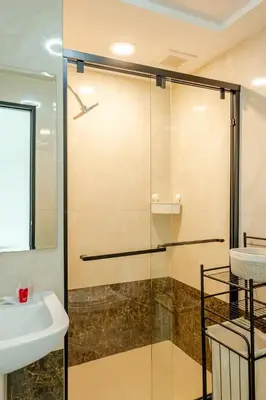 a shower with a glass door next to a sink at Room 402 Rawai Beach Condo in Nai Harn Beach