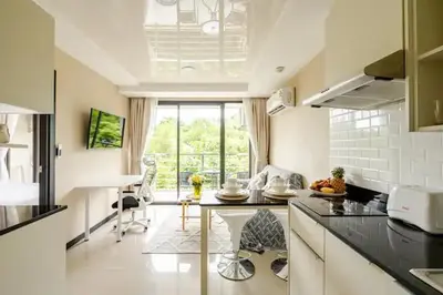 a kitchen with a table in the middle of a room at Room 402 Rawai Beach Condo in Nai Harn Beach