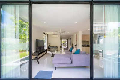 a living room with glass doors and a purple couch at Modern Minimalist 6 Bedroom Light Luxury Villa Private Pool Golf Course Laguna Park in Bang Tao Beach